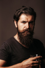 bearded man with glass of brandy or whiskey