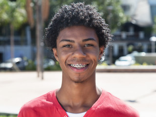 Happy latin american guy with dental braces