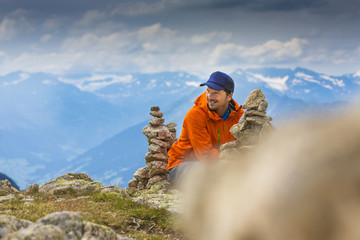 Wanderer in den Alpen vor Steinmandln am Gipfel