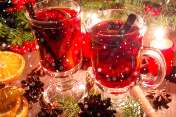 christmas mulled wine with spices and orange in the candle light