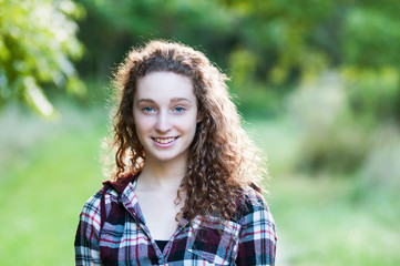 pretty teen girl with curly hair outdoors
