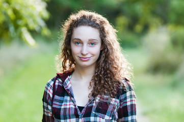 pretty teen girl with curly hair outdoors