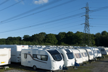 Caravans stored in rows on a sunny day.