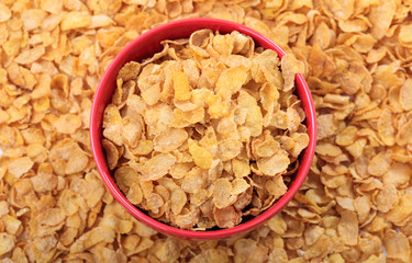 Bowl with corn flakes on corn flakes background