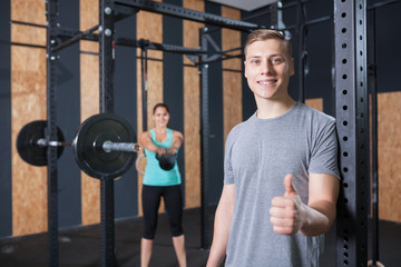 sportsman showing thumbs up at gym