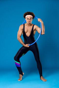 Sportive african man posing with hoop over blue background. © Cookie Studio