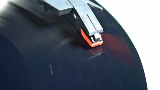 An old record spinning on a turntable isolated on white. UHD - 4K