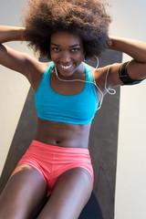 Fototapeta na wymiar Happy healthy young African American woman working out and liste