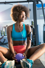 Fototapeta na wymiar Happy healthy young African American woman working out and liste