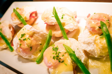 Eggs Benedict- toasted English muffins, ham, poached eggs aspara