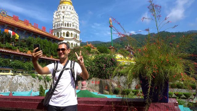 Caucasian man taking photo of Chinese temple