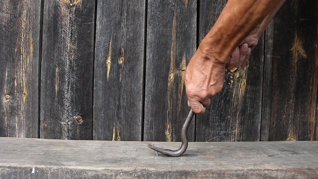 Crowbar pulled out the nail. The man pulled a nail from the old Board.