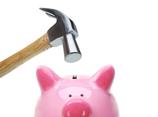 A sad pink piggy bank is about to be hit by a hammer in old vintage tone / Financial problem