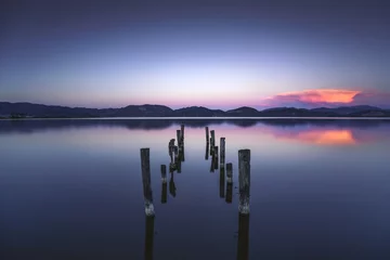 Türaufkleber Hölzerner Pier oder Steg bleibt auf einem blauen Seesonnenuntergang und -himmel refle © stevanzz