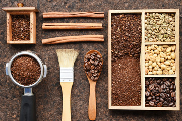 Coffee beans with ground coffee in wooden spoon and cinnamon
