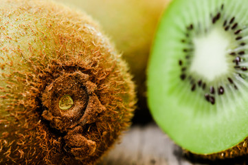 Some fresh Kiwi Fruits (selective focus) on an old wooden table, half of kiwi