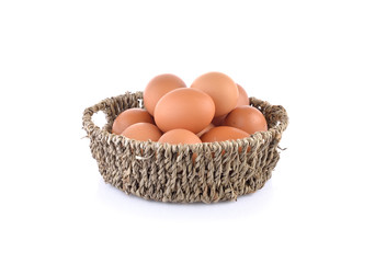 fresh raw eggs in basket and on white background
