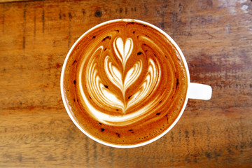 cup of latte art coffee on wooden background