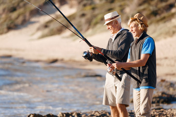 Senior man fishing with his grandson