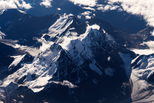 Fototapeta Snow capped mountains range with a bird's eye view from airplane, Leh, Ladakh, India. Aerial view on earth from the window of a flying plane.