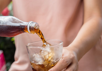 glass of cola with ice cubes.