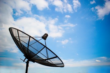 Satellite dish on blue sky and clouds.