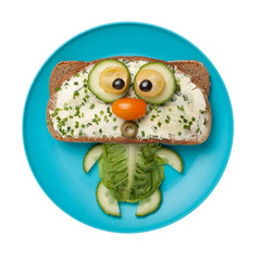 Funny cat made of bread and vegetables on plate