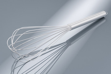 wire whisk on grey background