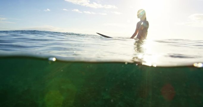 Beautiful surfer girl enjoying sunset surf