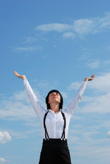 Woman standing on grass on background of blue sky