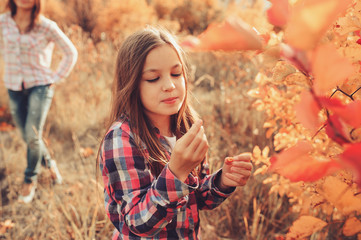 happy kid girl eating berries on cozy warm autumn walk, outdoor activities