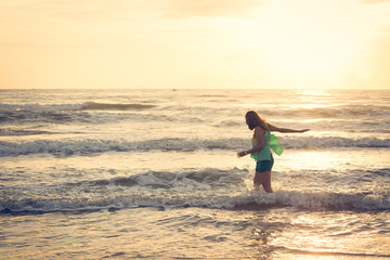 Fototapeta na wymiar woman walking on the beach, sunshine in the morning