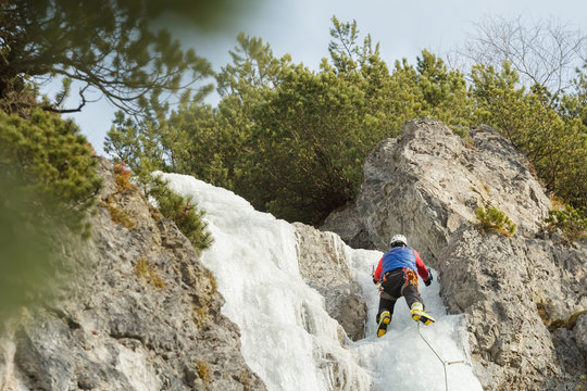 Sportsman working on winter ice climbing route outdoors