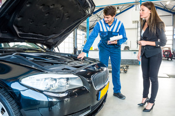 Mechanic Talking To Female Customer About Car Engine