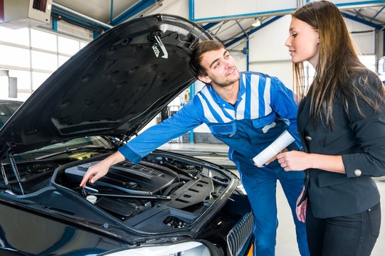 Mechanic Explaining Problems To Customer In Garage