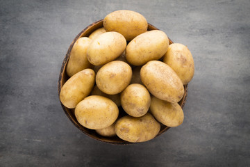 New potato on the bowl, gray background.