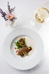High French cuisine. Grilled fish with vegetables and foam sauce
