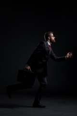 Businessman running hurry on a black background