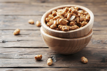 Sugared peanuts on the wooden background