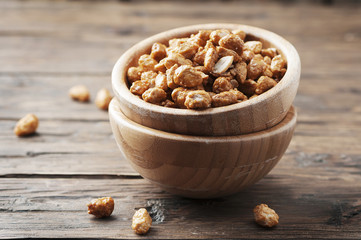 Sugared peanuts on the wooden background