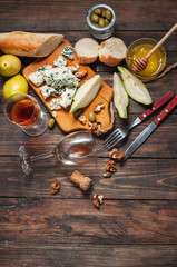Blue cheese with honey, olive and pears on rustic table