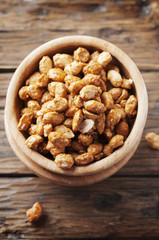 Sugared peanuts on the wooden background