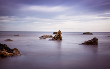 Fototapeta na wymiar Lush Purple Sky and Sea Beach Scene