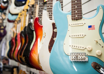 Many electric guitars body aligned in the store