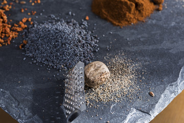 herbs and spices cutlery on dark colored stones.