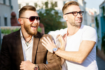 Two cheerful stylish guy met on sunny summer day