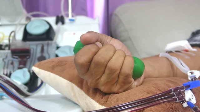 blood donor squeezes the ball in his hand during single donor platelets blood separation machine working