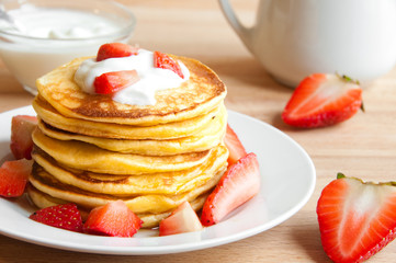 Pancekes with sour cream and strawberries for breakfast