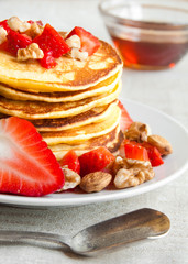 Pancakes with maple syrop,  strawberries and nuts for breakfasr