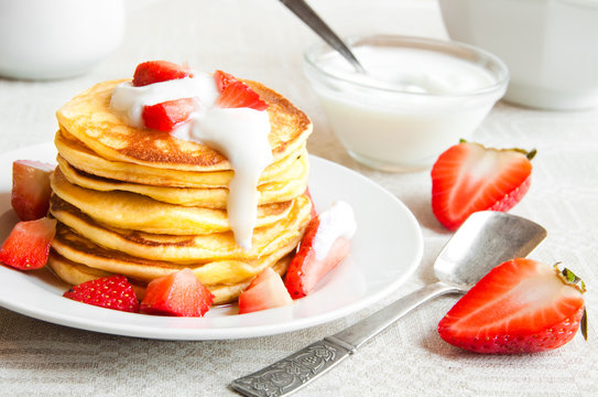 Pancekes with sour cream and strawberries for breakfast